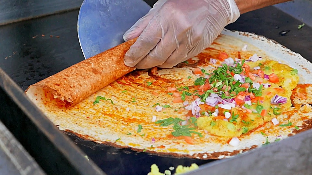 Chef preparing fresh dosas on traditional tawa